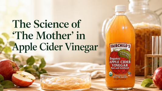 Fairchild’s Organic Apple Cider Vinegar beside apples and visible vinegar Mother fermentation material.