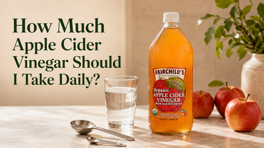 Fairchild’s Organic Apple Cider Vinegar bottle beside a glass of water and measuring spoons showing how to dilute a daily serving.